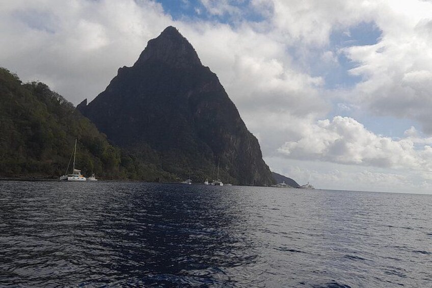 A mountainous landscape with a body of water in the foreground and a sailboat in the distance. 3