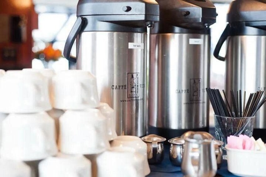 Mostrador de cafetería con máquinas de espresso, espumadores de leche y una pila de vasos desechables. 2