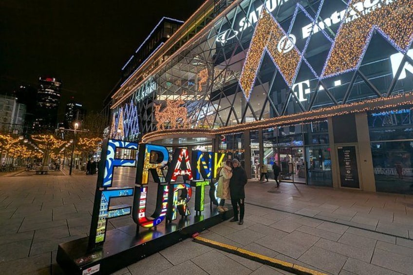 A brightly lit building with a large sign reading 'RAP KULTUR' and a glass facade. 2