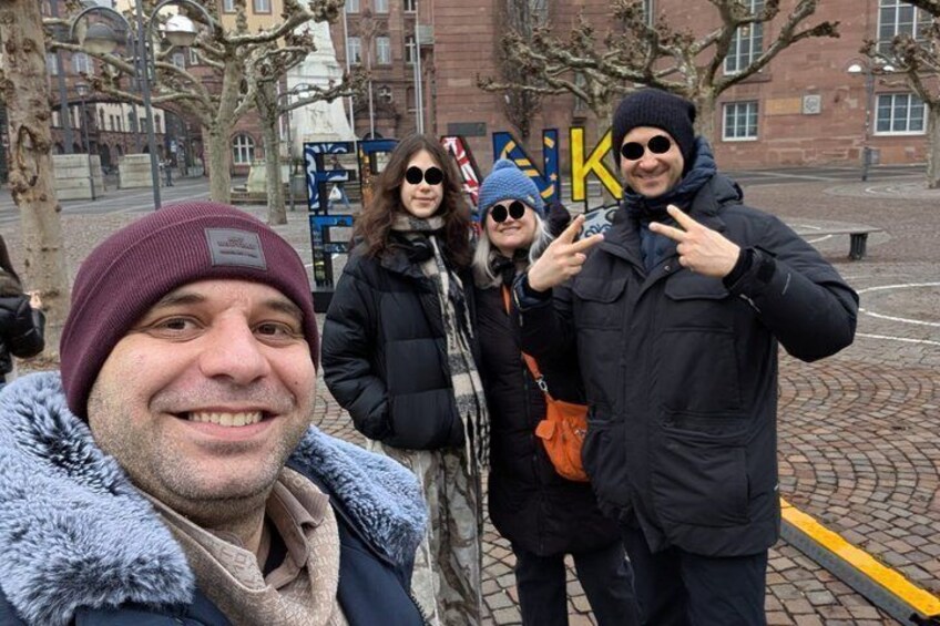 A group of people standing outdoors with a building in the background. 4