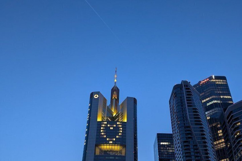 A city skyline with illuminated buildings against a clear sky. 5