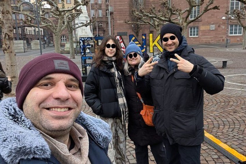 A group of people standing outdoors with a building in the background. 4