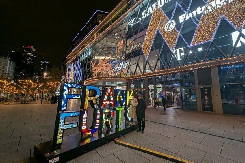 A brightly lit building with illuminated letters spelling 'RAP KENT' and a sign for 'ENTERTAINMENT.' 2