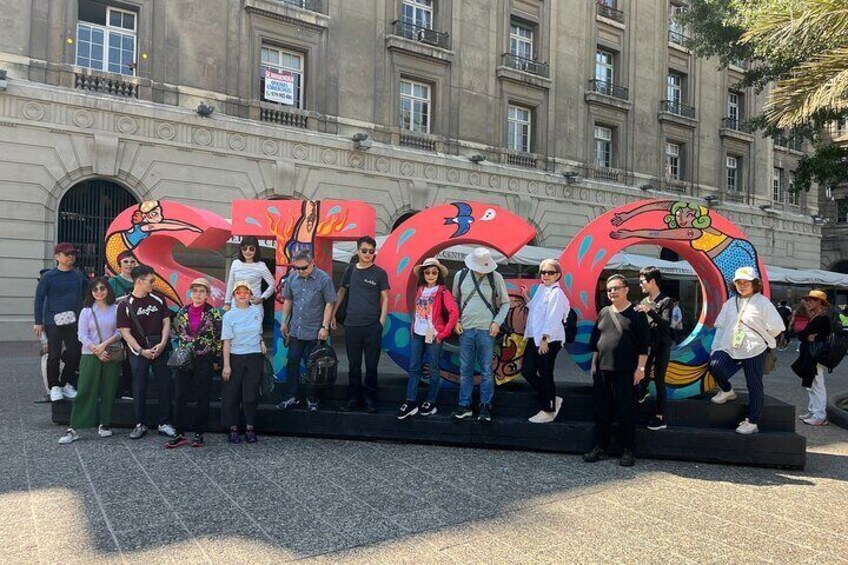A group of people standing in front of colorful, abstract sculptures. 4