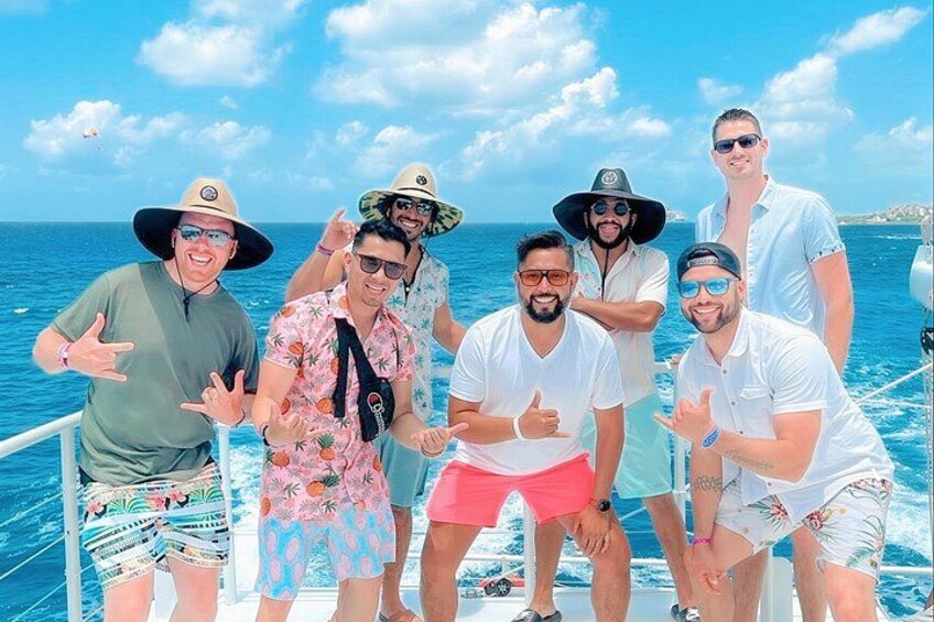 A group of people on a boat with the ocean and a clear sky in the background. 1