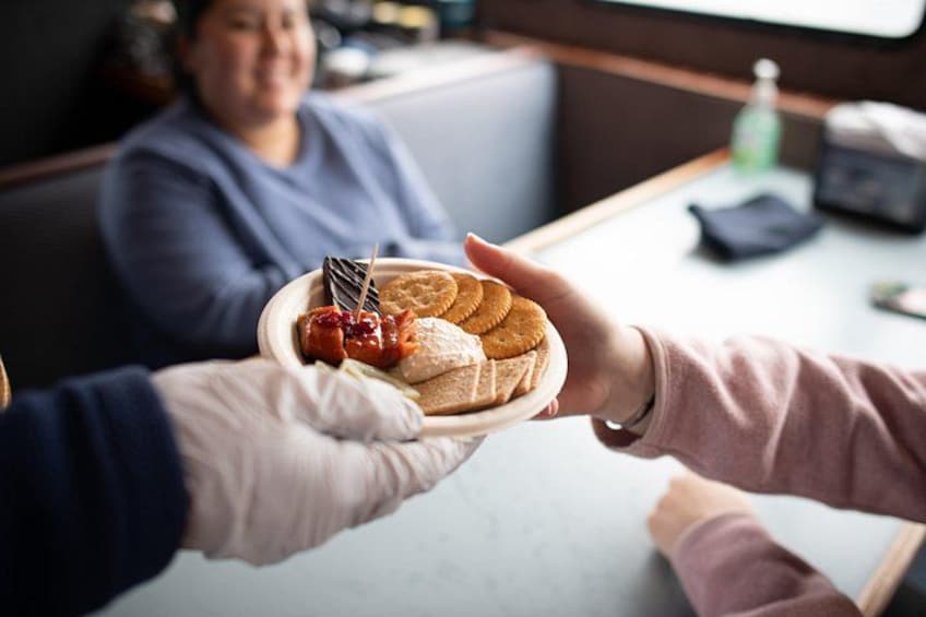 A person holding a plate with cookies and a piece of cake. 3