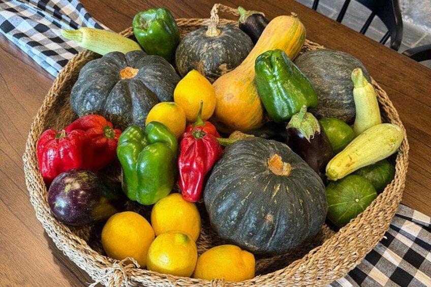 A basket filled with various vegetables and fruits on a wooden table. 4