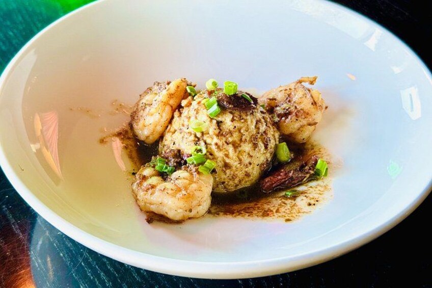 A bowl of food with scallops and a sauce, garnished with green onions. 3