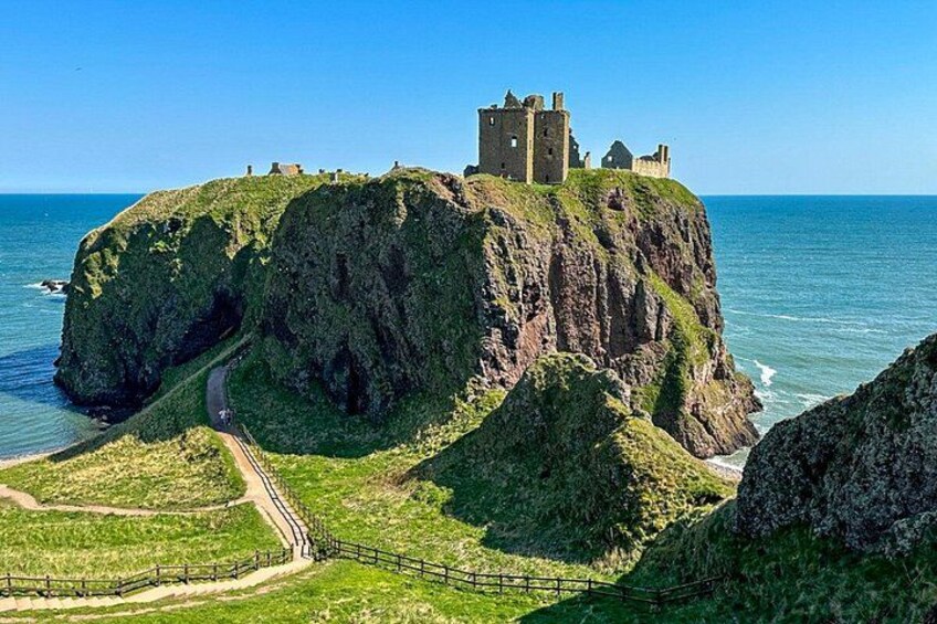 A coastal castle on a cliff, a pathway leading to it, and the surrounding sea. 5