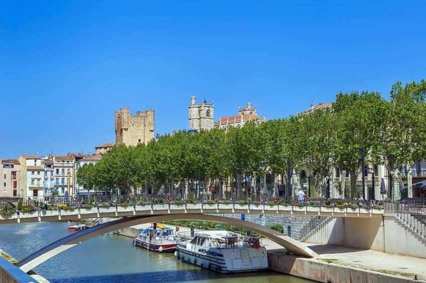 A river with boats, a bridge, and historic buildings in the background. 1