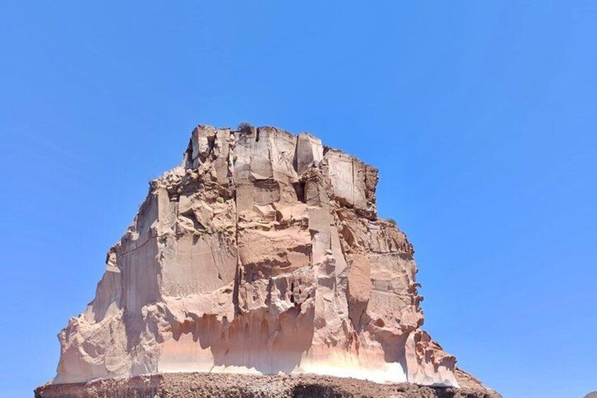 A large rock formation with layered sedimentary rock. 4