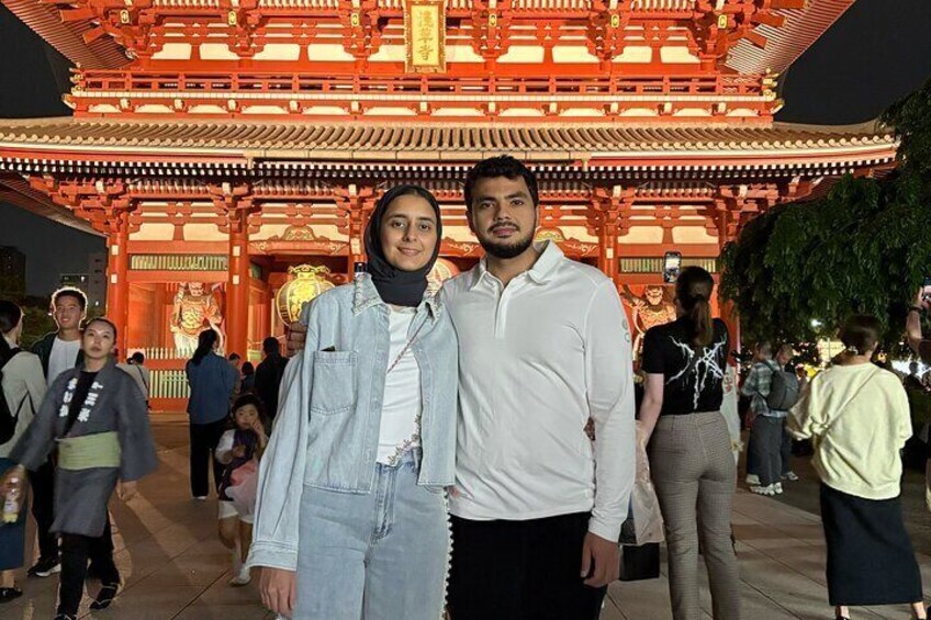 Deux personnes se tiennent devant un portail torii japonais traditionnel. 2