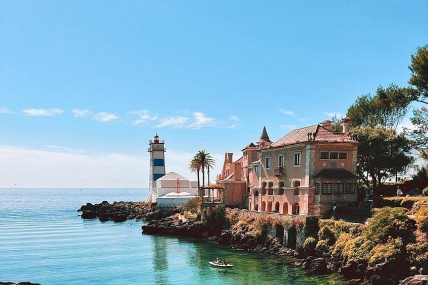 Escena costera con un faro, una casa grande y agua azul cristalina. 4