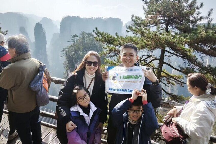 A group of people on a wooden platform with a mountainous landscape in the background. 4