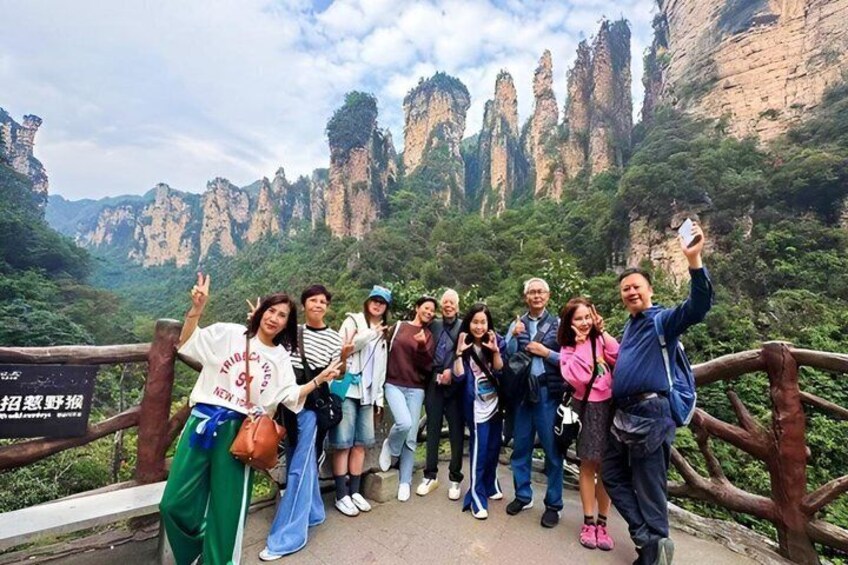 A group of people posing on a bridge with a mountainous landscape in the background. 2