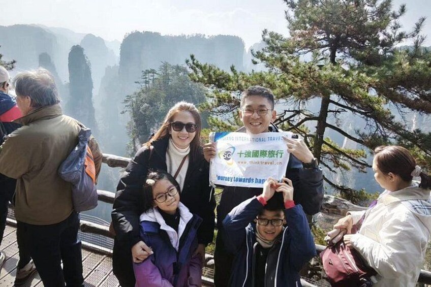 A group of people on a wooden platform with a mountainous landscape in the background. 4