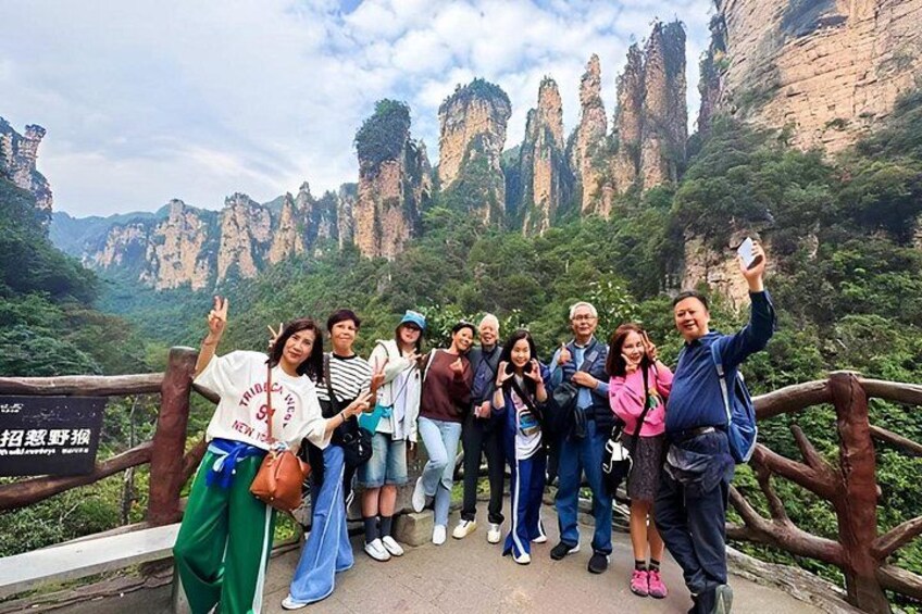A group of people posing on a bridge with a mountainous landscape in the background. 2