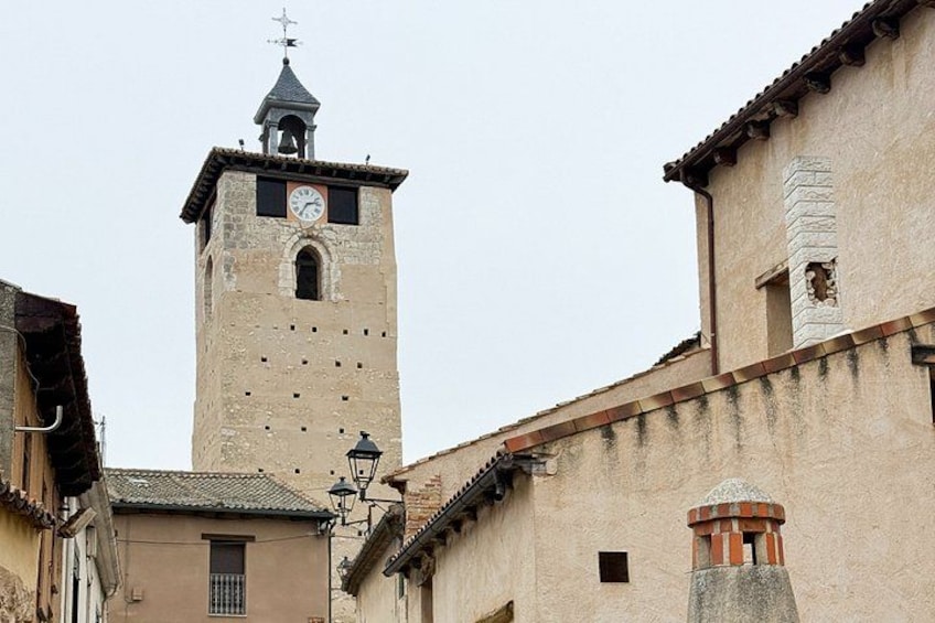 A historic tower with a clock, a bell, and a weather vane. 4