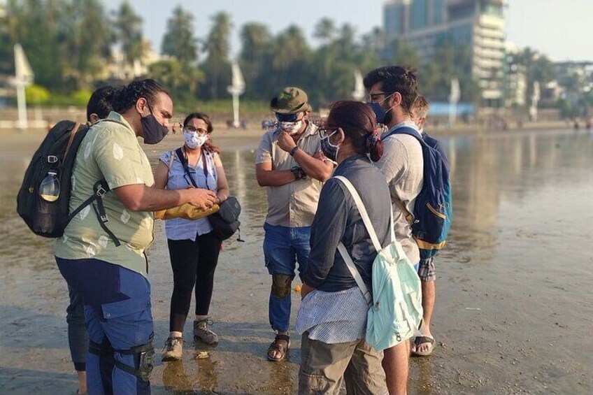 A group of people standing by a river, some wearing masks. 3