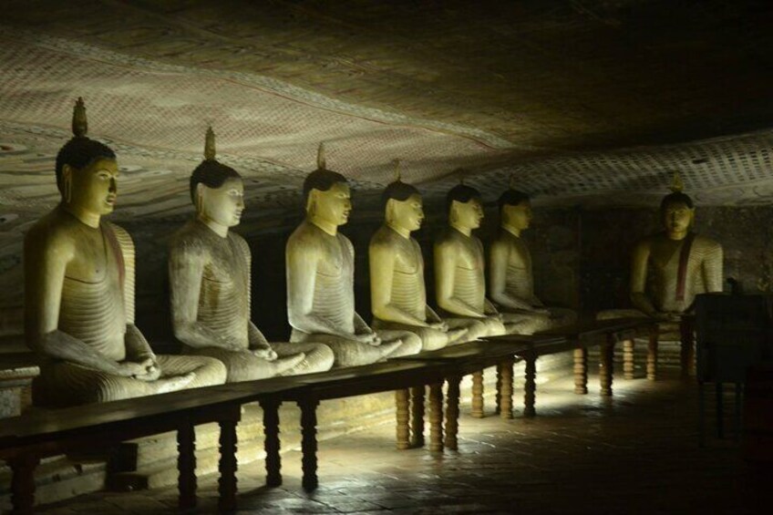 A row of seated Buddha statues in a cave. 3