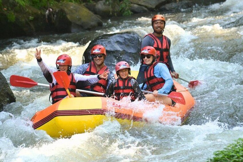 A group of people in a yellow raft navigating a river with rapids. 4