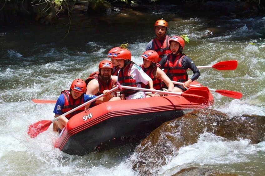 A group of people in a red raft navigating a river. 2