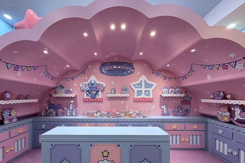 Ein zartrosa eingerichtetes Zimmer mit Sternenhimmel, Regalen voller Spielzeug und einem zentralen Tisch. 3