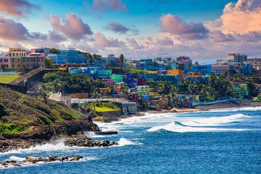 A coastal town with colorful buildings, a rocky shoreline, and waves crashing onto the beach. 4