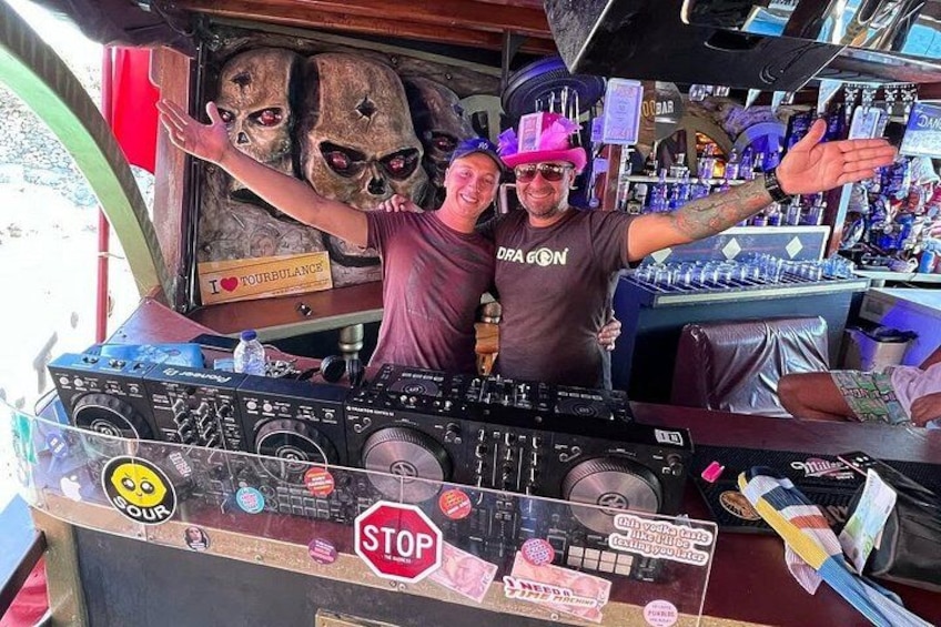 A DJ booth with a stop sign, a skull decoration, and a sign that says 'I love Tourbulence.' 4