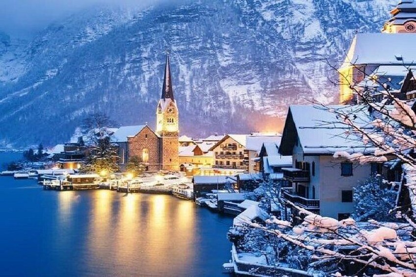 A snow-covered village with a church, buildings, and a mountain in the background. 3