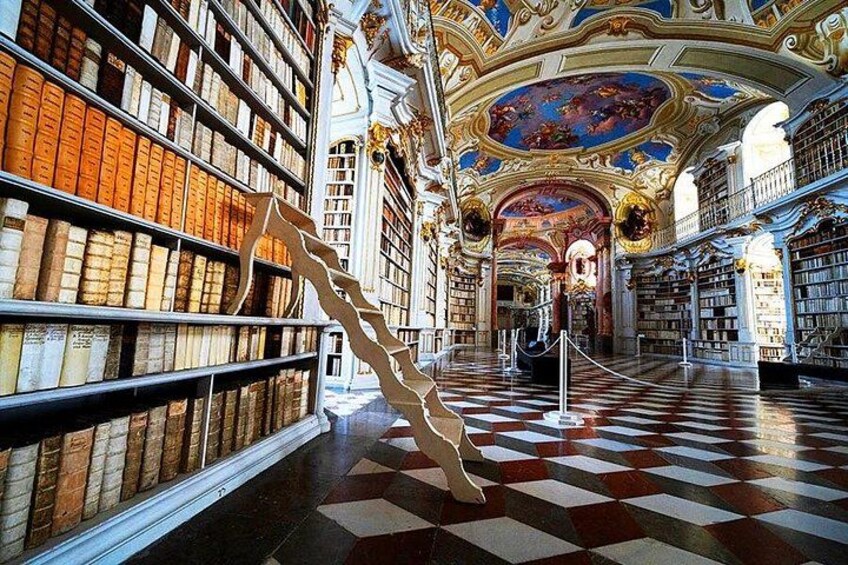 A library interior with ornate ceilings, bookshelves, and a checkered floor. 3
