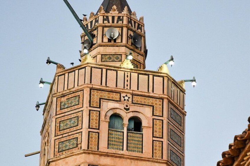 A tower with intricate patterns and a star symbol, surrounded by street lamps. 2