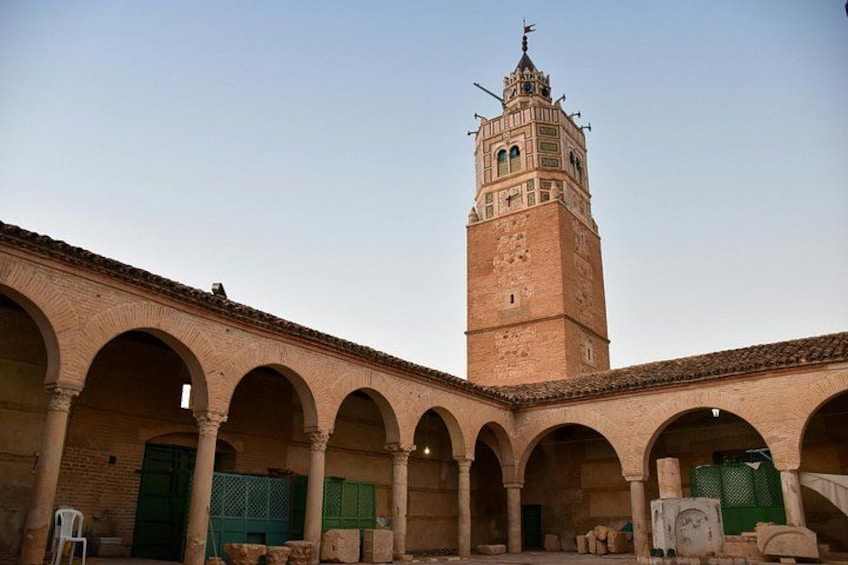 A historic building with a tall tower and arched colonnade. 3
