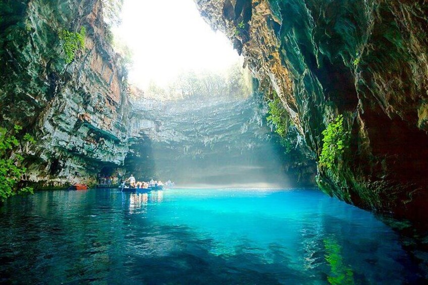 A boat on a clear blue water body surrounded by rocky cliffs. 2