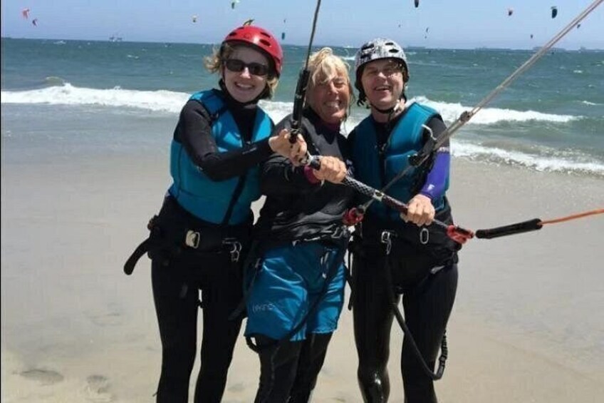Tre personer på en strand med drager. 3