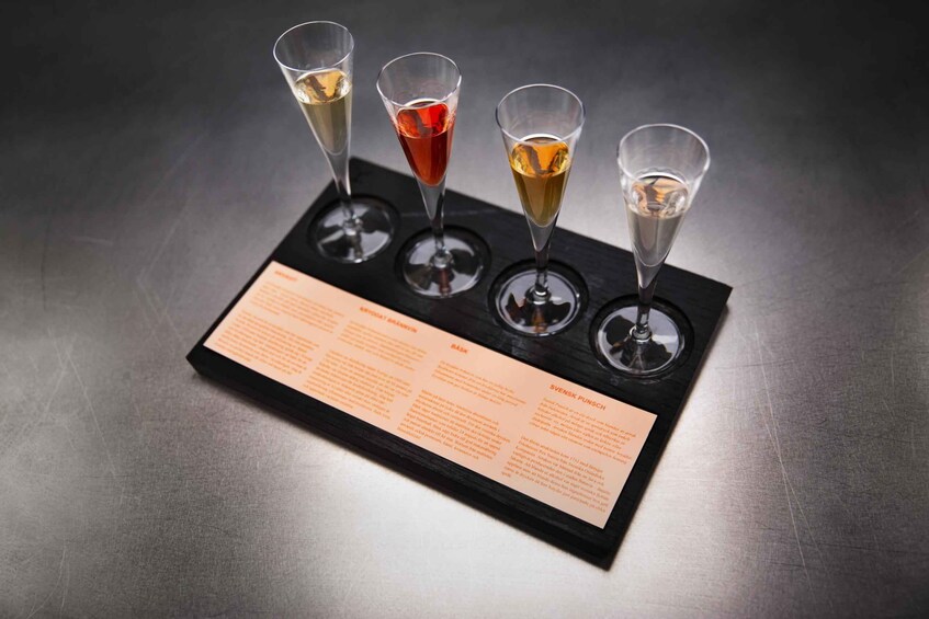 Four glasses of different colored drinks on a tray with a menu. 3