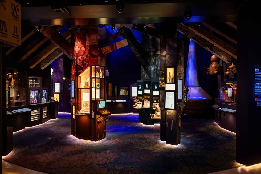 A dimly lit museum with exhibits on the left and right, a central display case, and a large, illuminated sculpture. 2