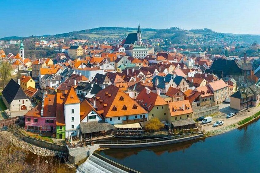 A town with colorful buildings, a river, and a distant hill. 3