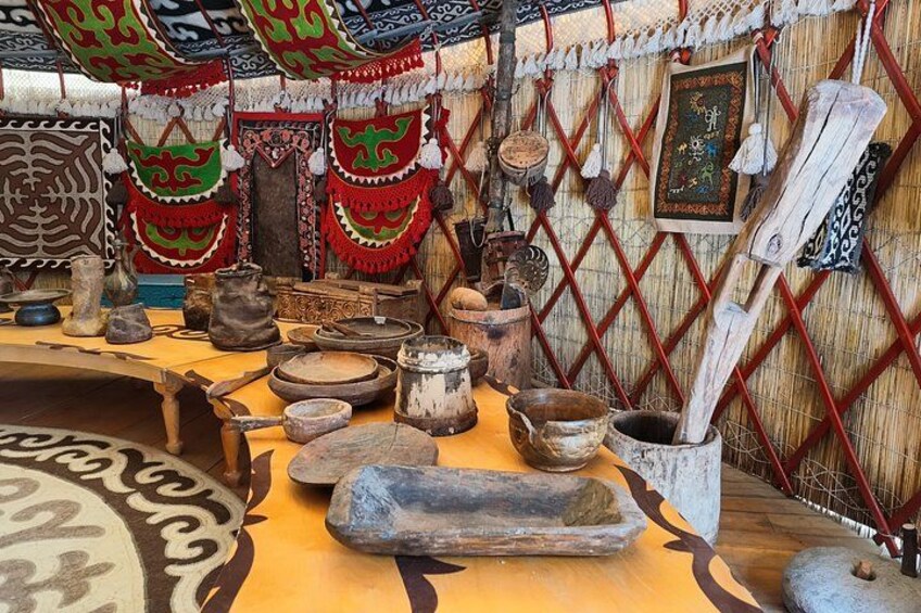 A traditional setting with wooden furniture, pottery, and decorative textiles. 2