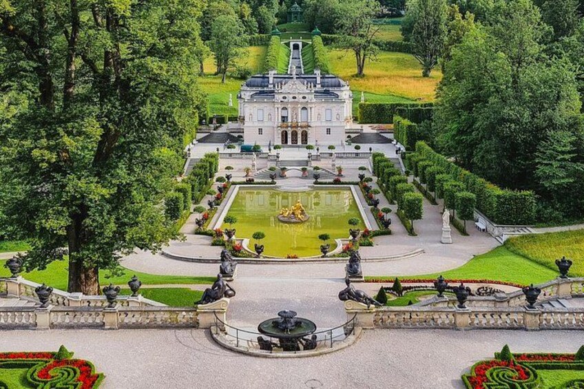 A grand estate with a central fountain, manicured gardens, and classical architecture. 3