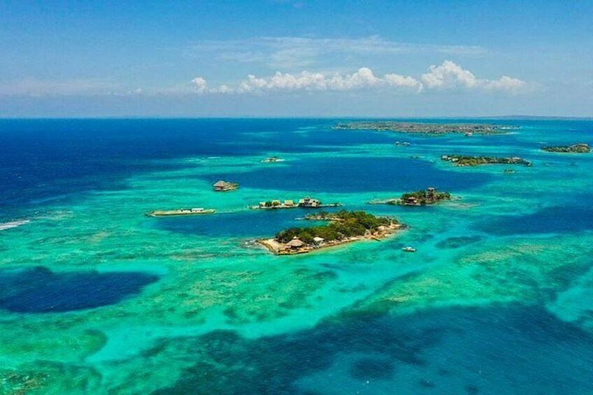 A turquoise sea with clear waters and several small islands with structures. 2