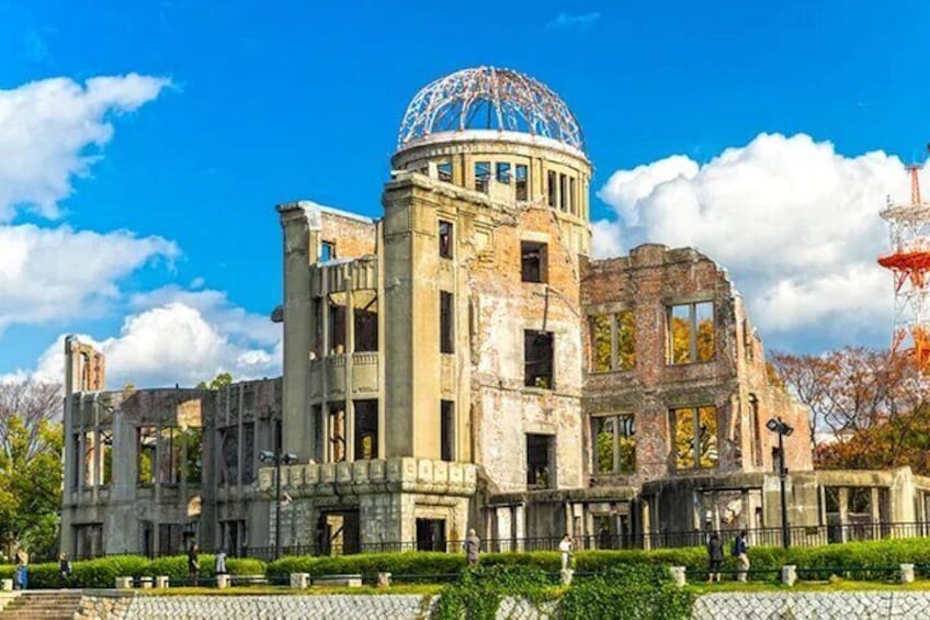 A large, historic building with a dome and columns, surrounded by a well-maintained garden. 1