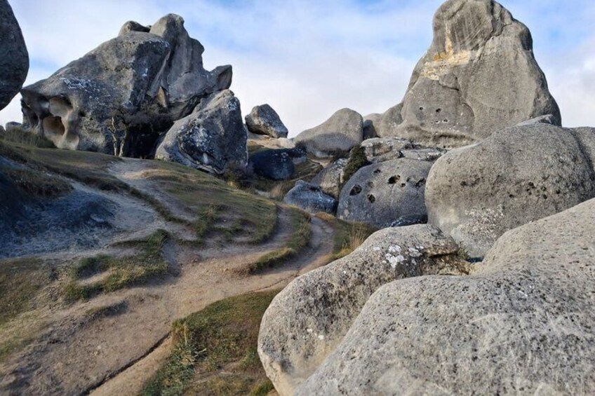A rocky landscape with large boulders and a winding path. 5