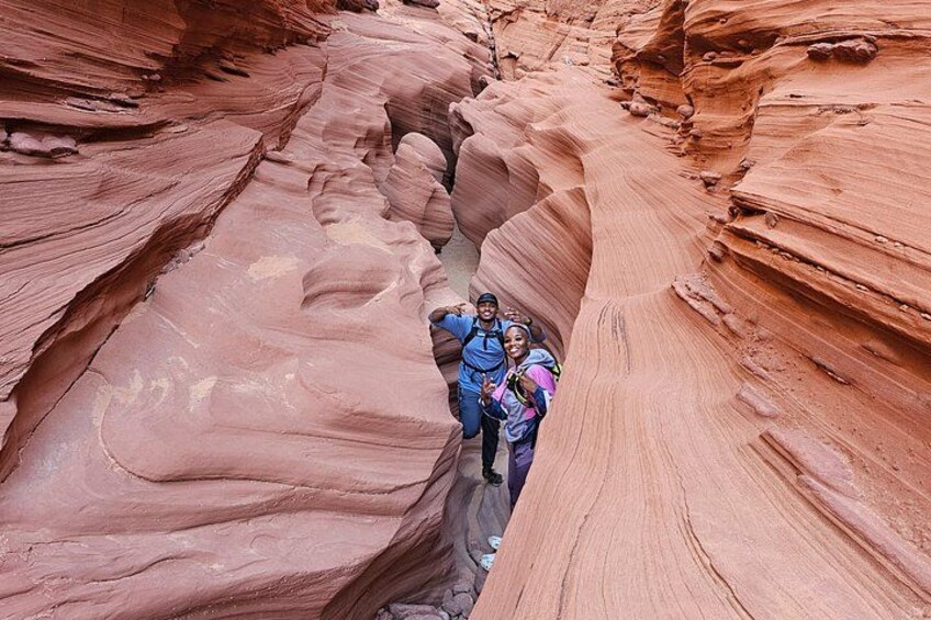 A canyon with layered red rock formations and a group of people hiking. 3