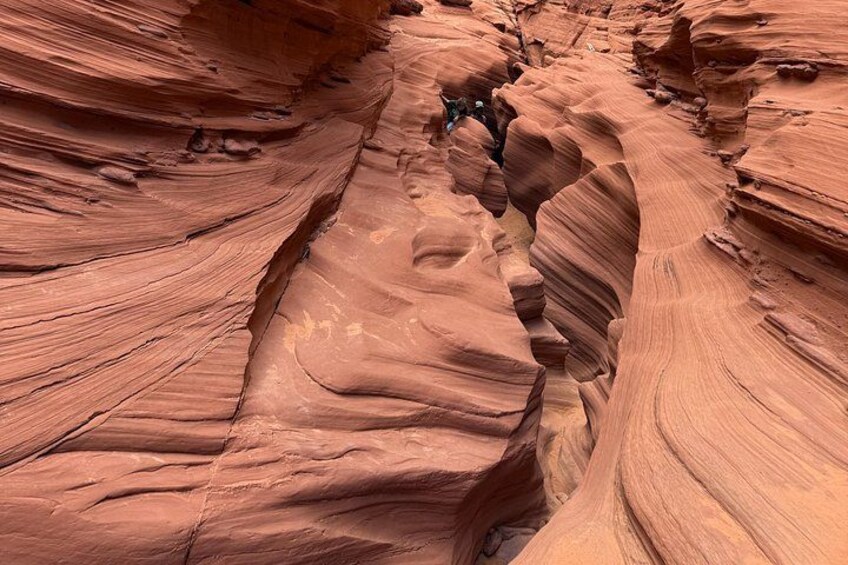 A canyon with layered rock formations and a narrow passage. 4