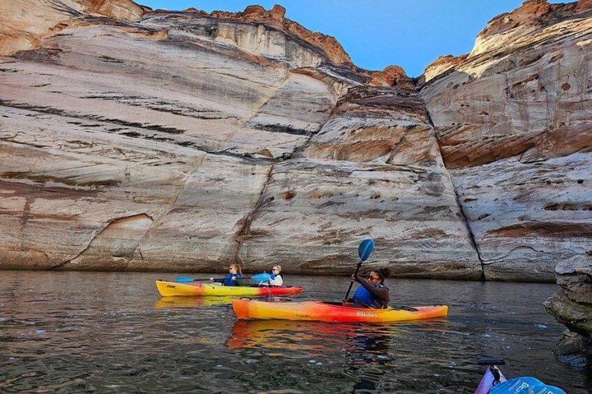 Two kayaks on calm water with rocky cliffs in the background. 5