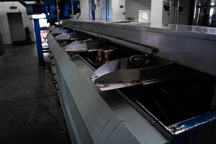 A conveyor belt system in a manufacturing facility with metal components and machinery. 4