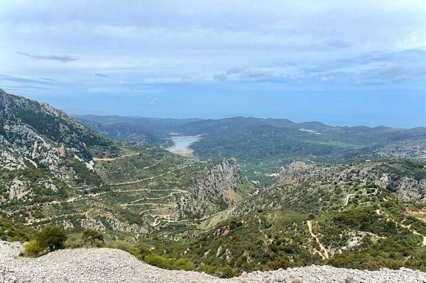 A mountainous landscape with a river, rocky terrain, and sparse vegetation. 3