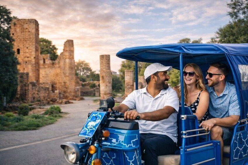 A blue vehicle with a map design driving past ancient ruins. 4