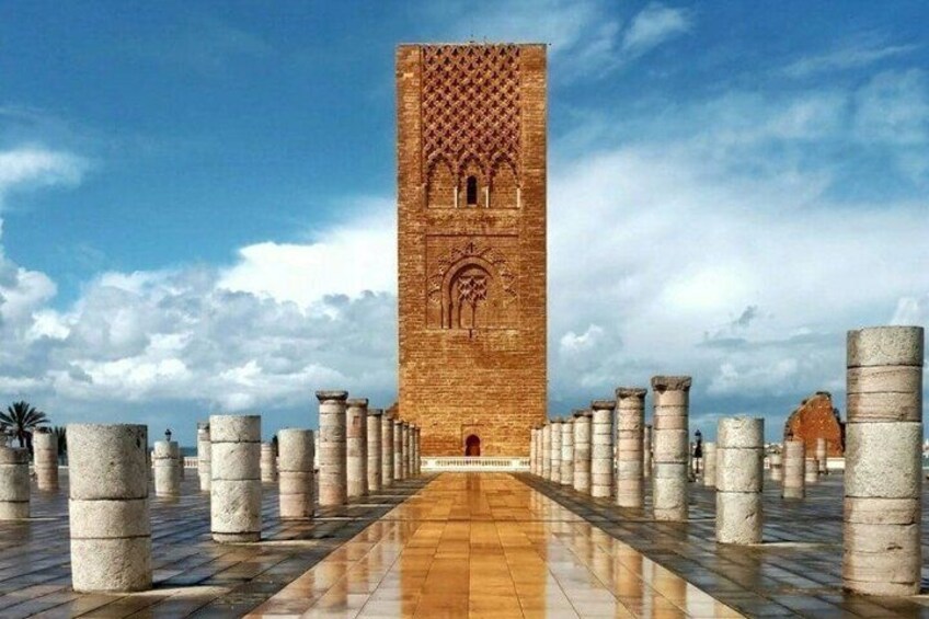 A tower with intricate carvings, a paved walkway, and stone columns. 2